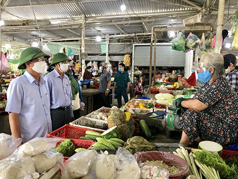 Ông Nguyễn Tấn Tuân trao đổi với bà Hồ Thị Bé - tiểu thương chợ Vĩnh Phương trong việc tuyên truyền phòng dịch cho nguwoif dân