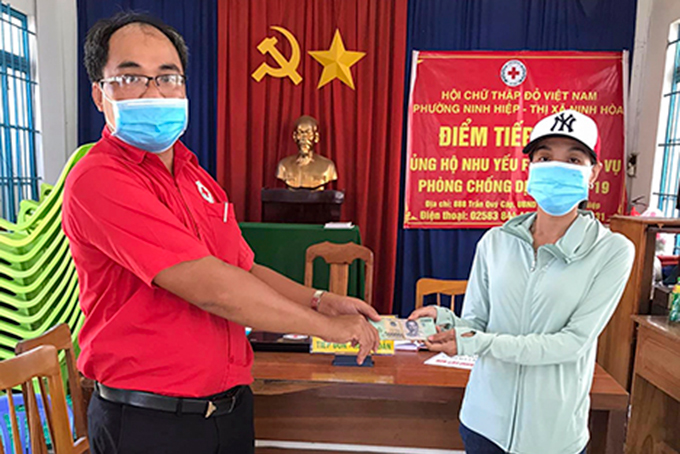 Đại diện Hội Chữ thập đỏ phường Ninh Hiệp, thị xã Ninh Hòa trao tiền hỗ trợ của gia đình chị Trân cho lực lượng test nhanh của Trung tâm Y tế thị xã Ninh Hòa.