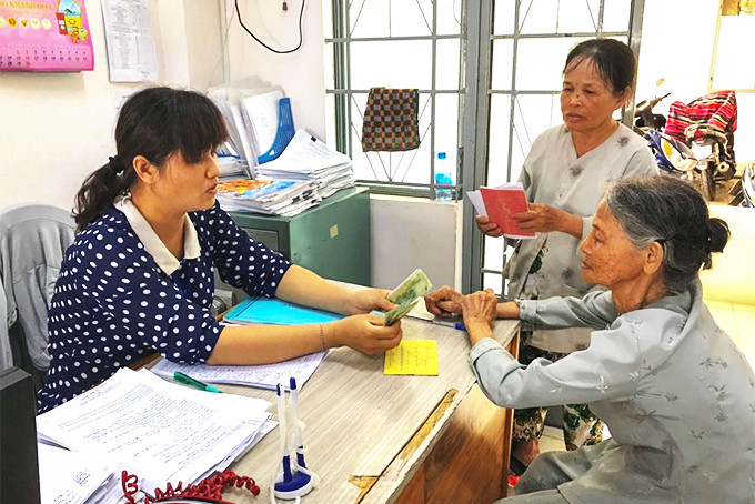 Chi trả chế độ trợ cấp hàng tháng cho người có công với cách mạng  ở phường Phước Long (TP. Nha Trang). (Ảnh chụp trước tháng 4-2021)