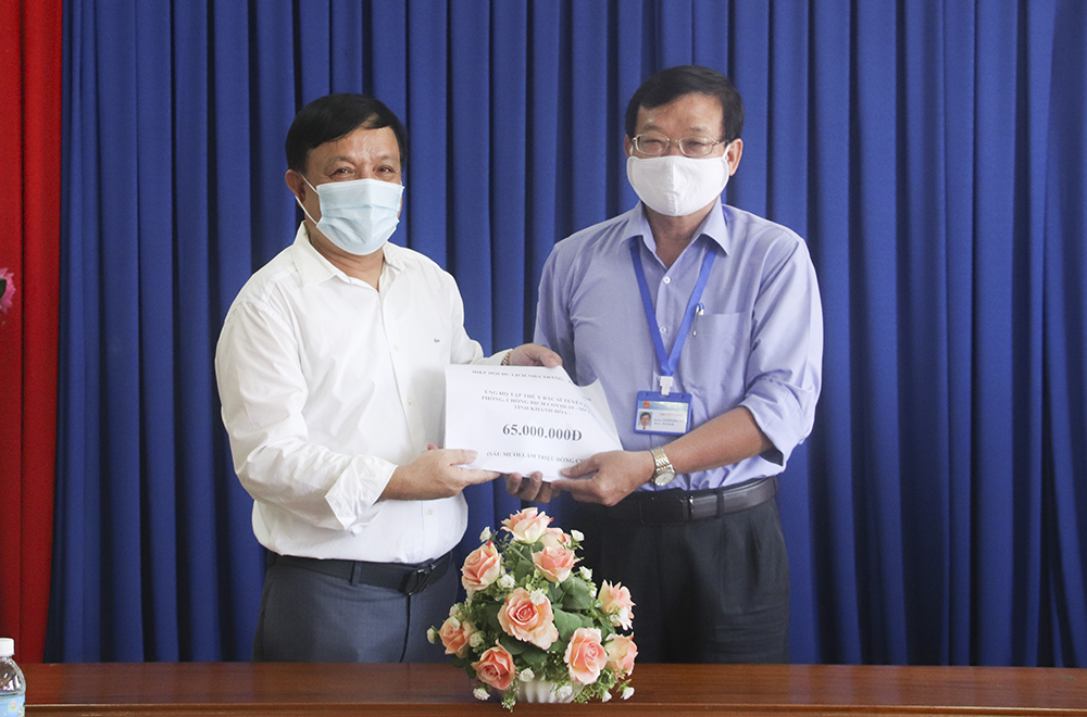 Ông Hoàng Văn Vinh - Chủ tịch Hiệp hội Du lịch Nha Trang - Khánh Hòa trao số tiền ủng hộ cho lãnh đạo Sở Y tế