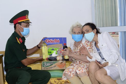 Trung tá Võ Thành Tâm trao quà tặng gia đình bà Rita.