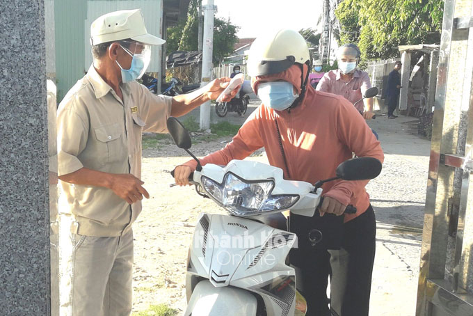Người dân xã Vạn Thắng (huyện Vạn Ninh) kiểm tra thân nhiệt người dân khi vào khu dân cư  