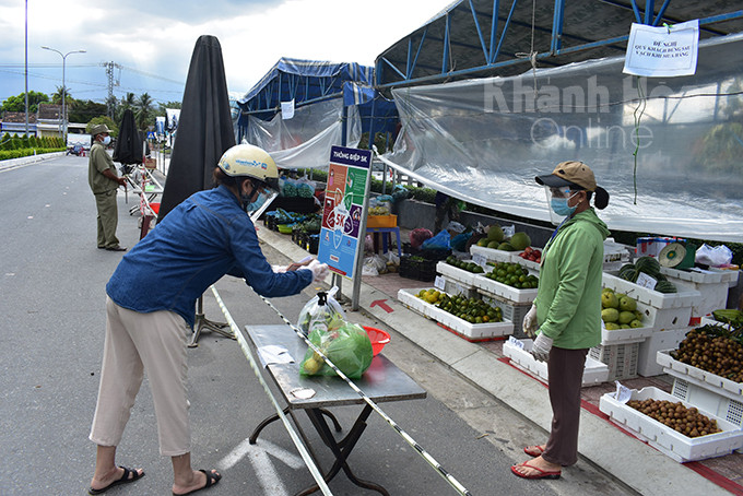 Thành viên tổ đi chợ hộ của phường Vạn Thạnh đi chợ mua hàng giúp người dân