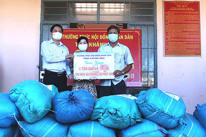 Ông Trần Mạnh Dũng (bìa trái) trao số gạo, trứng gà hỗ trợ người dân phường Cam Phúc Nam.