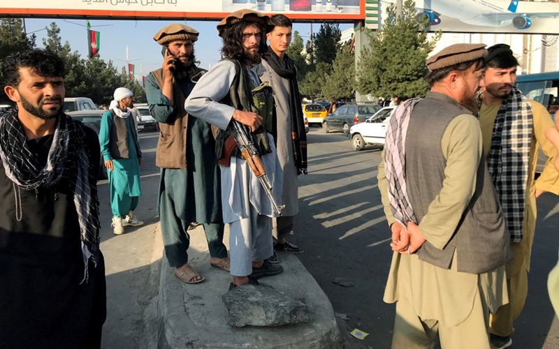 Một tay súng Taliban (giữa) đứng bên ngoài sân bay quốc tế Hamid Karzai, tại Kabul, ngày 16/8. (Ảnh: Reuters)