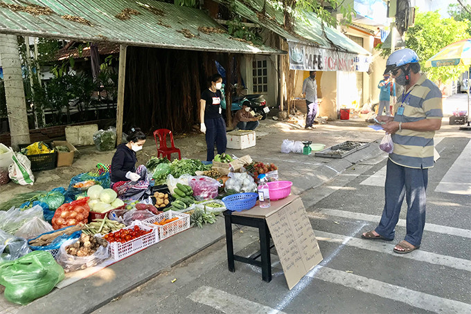 Đại diện tổ cứu trợ mua hàng giúp dân tại các gian hàng đường Bà Triệu. 
