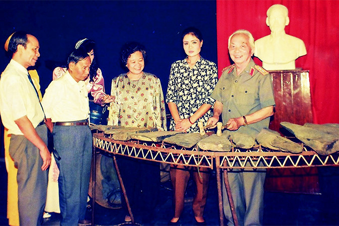 Đại tướng Võ Nguyên Giáp thử chơi đàn đá trong lần thăm Khánh Hòa năm 1994.  Ảnh: Nguyễn Viết Thái