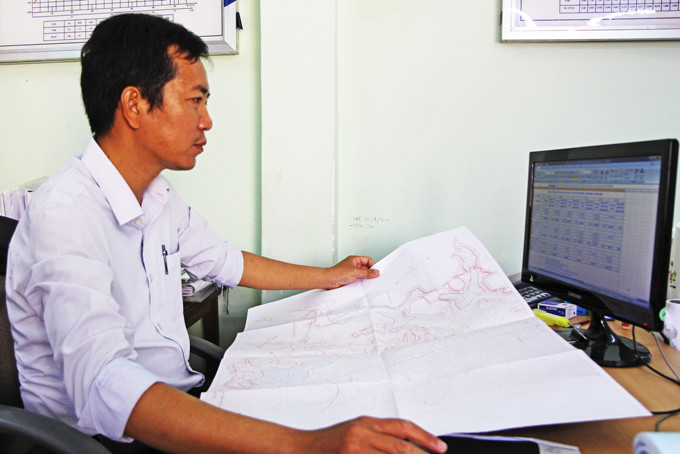 Kỹ sư Giang kiểm tra sơ đồ khu vực nạo vét  và số liệu khai thác tưới của các hồ chứa nước.