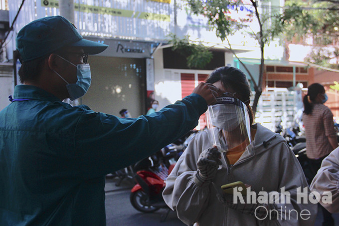 Getting body temperature checked before entering vaccination venue in Hoang Hoa Tham Street, Nha Trang