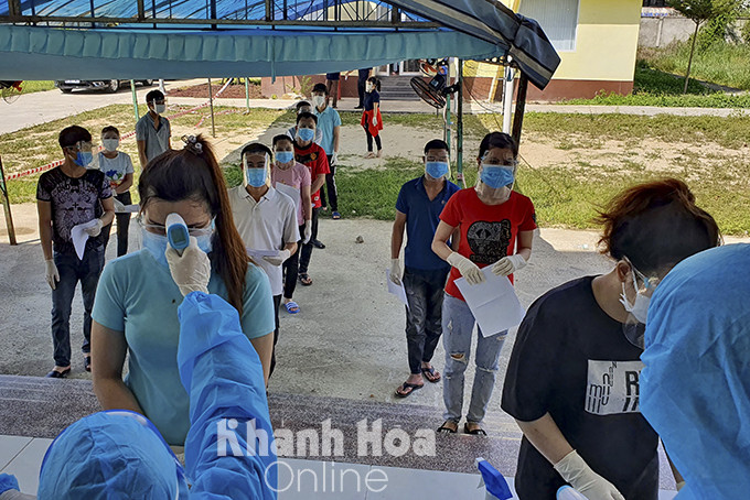 Workers in Suoi Dau Industrial Zone getting body temperature checked before entering vaccination venue