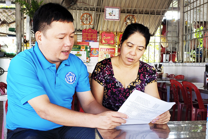  Cán bộ Bảo hiểm xã hội tỉnh truyền thông trực tiếp các chính sách bảo hiểm đến người dân xã Vĩnh Lương (TP. Nha Trang). (Ảnh chụp vào tháng 12-2020)