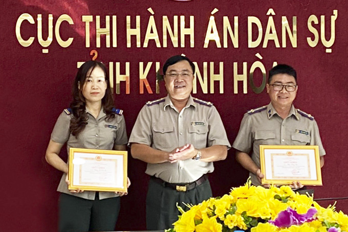 Chị Hà (bìa trái) nhận khen thưởng đảng viên hoàn thành xuất sắc nhiệm vụ năm 2020.