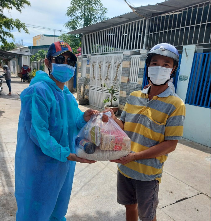 Thành viên của Nhóm Thiện nguyện Nha Trang trao quà cho người dân ở Tp. Nha Trang