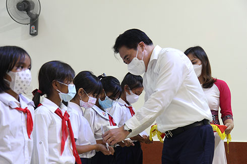 Ông Nguyễn Khắc Toàn tặng quà cho trẻ em.