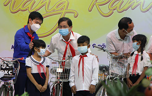 Ông Nguyễn Tấn Tuân tặng xe đạp cho học sinh. 