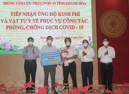 Đại diện Công ty TNHH Thương mại và Xây dựng Nguyên Hùng trao bảng tượng trưng hỗ trợ công tác phòng, chống dịch Covid-19 cho tỉnh