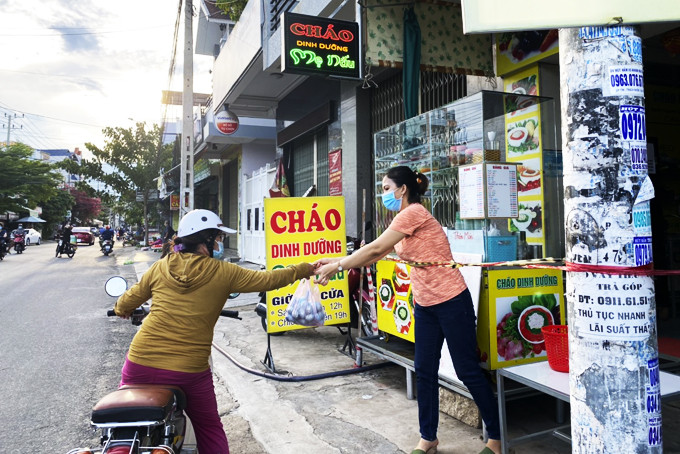 Một cơ sở kinh doanh dịch vụ ăn uống trên đường Nguyễn Khuyến thực hiện việc giăng dây giữ khoảng cách nhưng lại giao hàng trực tiếp cho khách, ảnh: VK