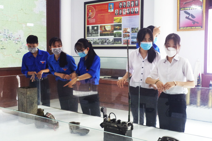 Học sinh, đoàn viên xem hiện vật trưng bày tại Nhà truyền thống lực lượng vũ trang huyện Khánh Sơn. Ảnh: Đinh Luận