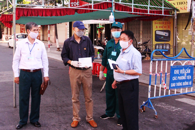 Ông Trần Văn Hạnh (bên phải) tặng quà, động viên các cựu chiến binh và lực lượng tham gia trực chốt kiểm soát  phòng, chống dịch Covid-19.