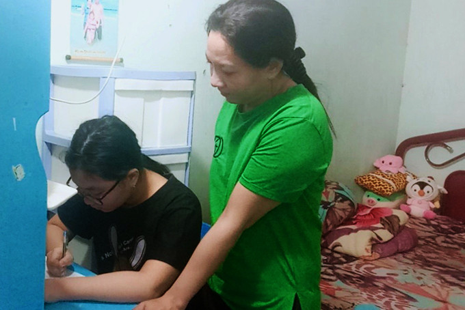 Chị Nguyễn Thị Thùy Linh hướng dẫn con học bài tại nhà.
