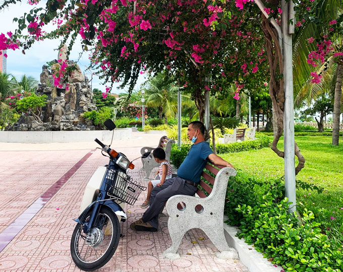 Người dân Nha Trang ngồi thư giãn dưới bóng mát vòm hoa giấy.