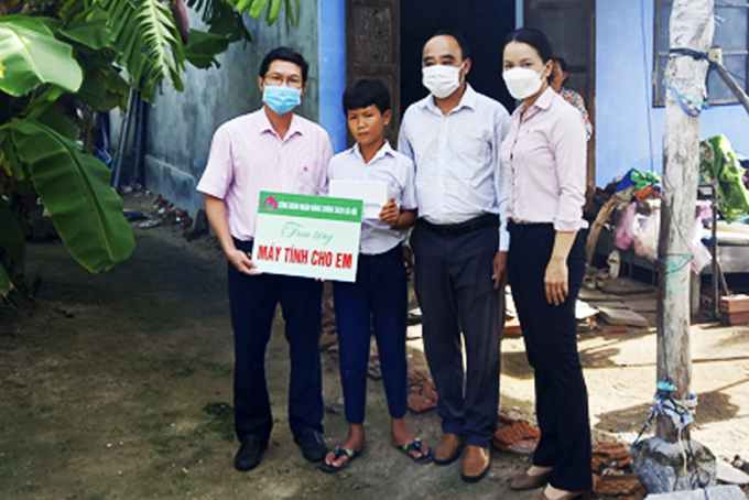 Đại diện Công đoàn Ngân hàng Chính sách xã hội tỉnh trao  máy tính bảng và sim cho học sinh ở xã Vạn Hưng, huyện Vạn Ninh.