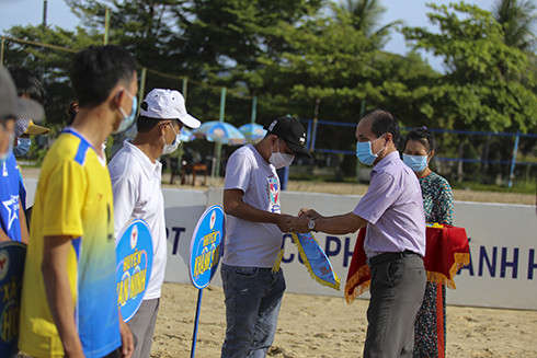 Nguyen Tuan Thanh, deputy director of the provincial Department of Culture and Sports offering souvenir flags to teams