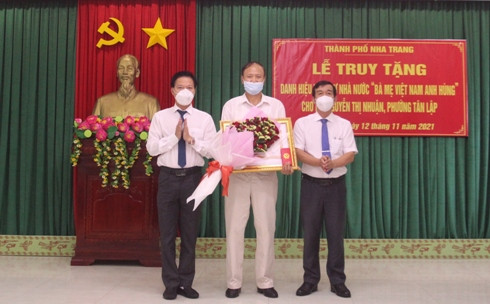 Thừa ủy quyền của Chủ tịch nước, ông Nguyễn Thế Sinh (bên phải) trao Bằng danh hiệu vinh dự Nhà nước cho thân nhân gia đình Mẹ Nguyễn Thị Nhuận.