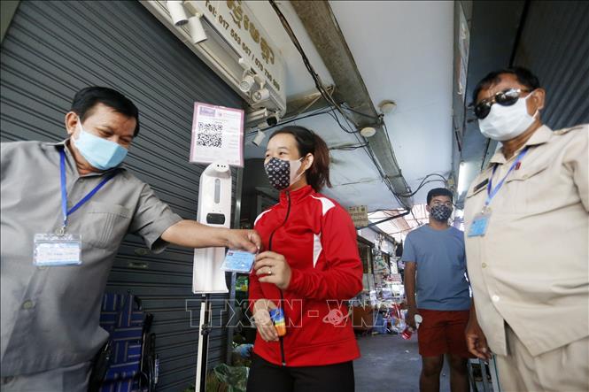  Kiểm tra chứng nhận tiêm phòng COVID-19 của người dân tại một khu chợ ở Phnom Penh, Campuchia. Ảnh: THX/TTXVN
