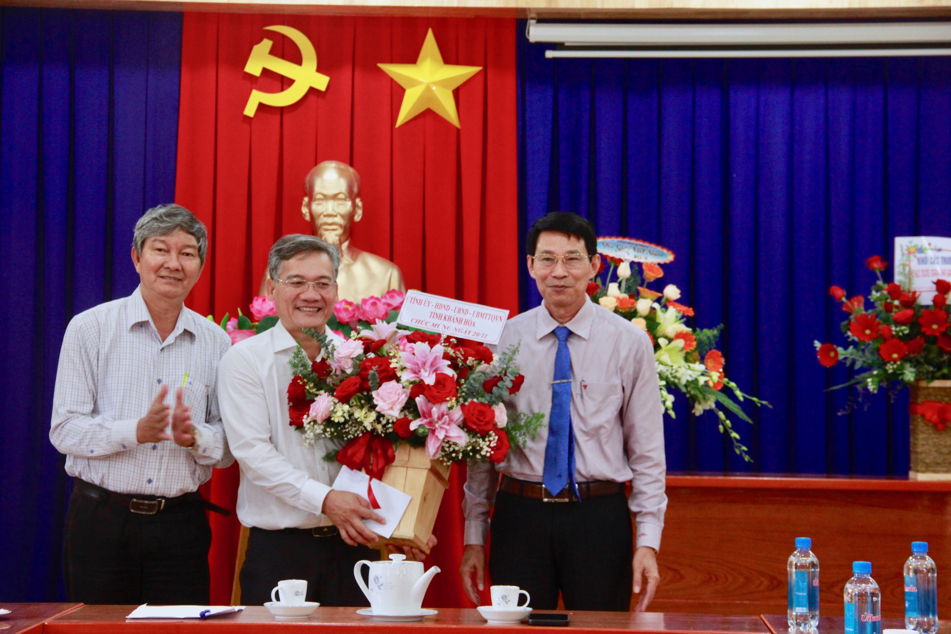 Ông Đinh Văn Thiệu (bên phải) tặng hoa cho lãnh đạo phòng Giáo dục và Đào tạo huyện Khánh Sơn