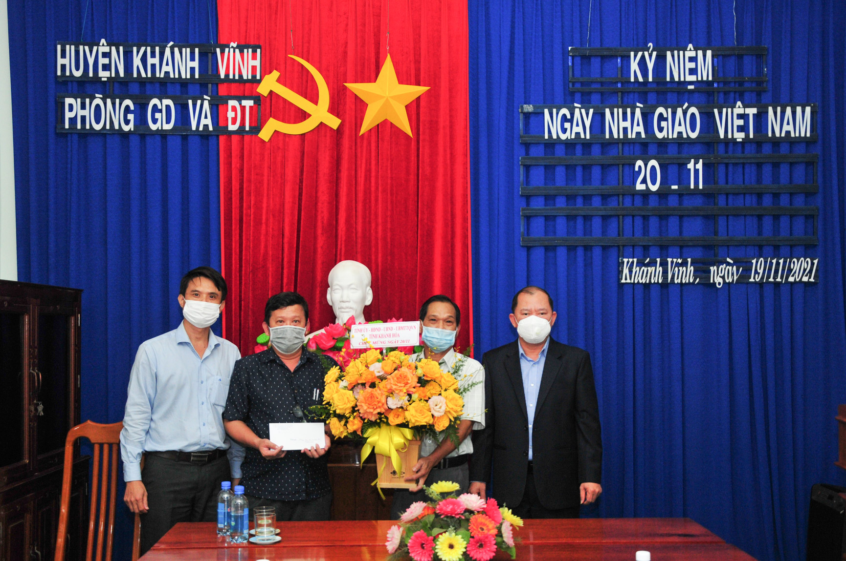 Đồng chí Nguyễn Anh Tuấn (bìa phải) tặng hoa và quà chúc mừng Phòng Giáo dục và Đào tạo huyện Khánh Vĩnh