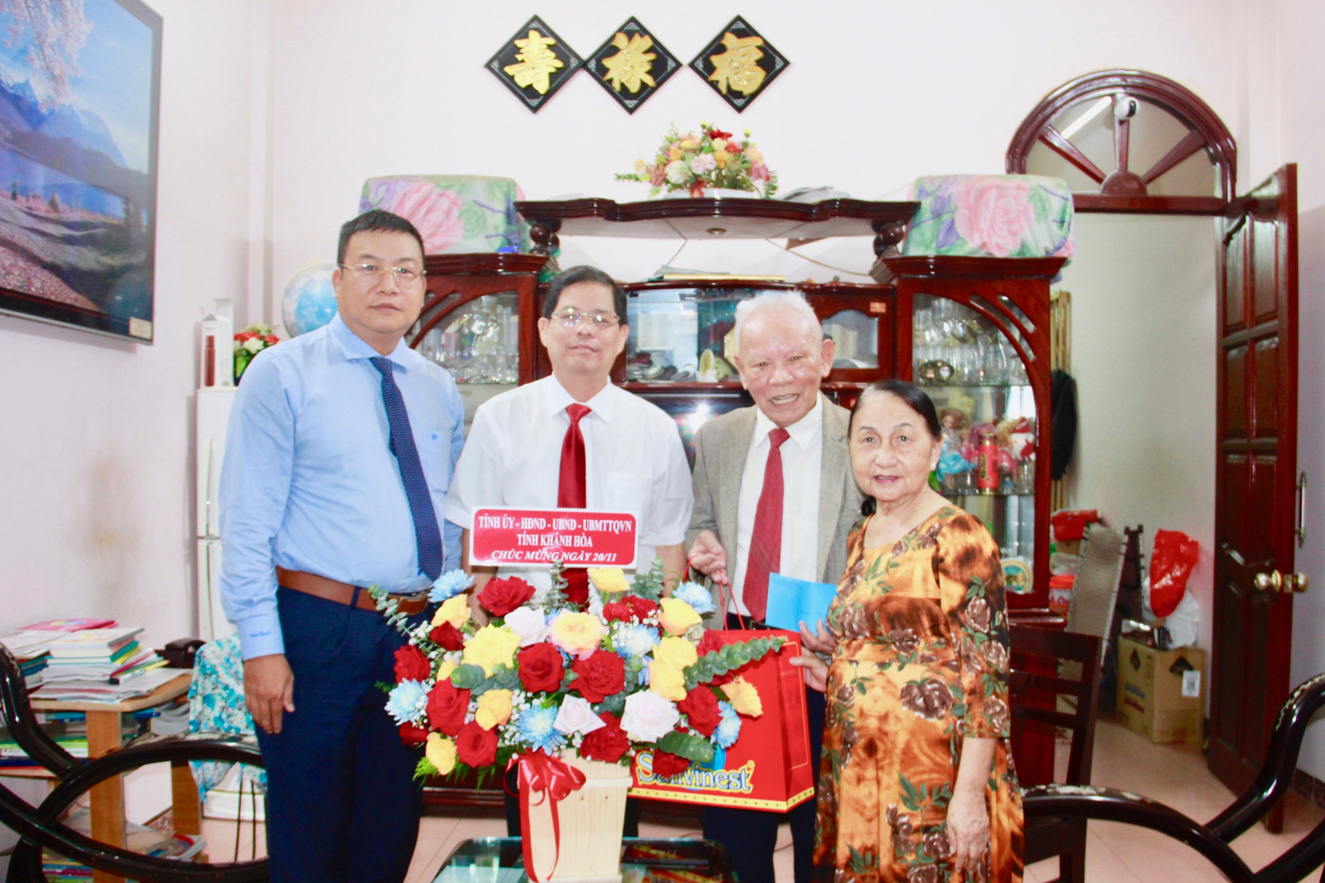 Ông  Nguyễn Tấn Tuân (thứ 2 từ trái sang) tặng hoa chúc mừng nhà giáo ưu tú Nguyễn Viết Cảnh.