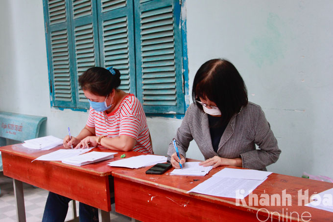 Giáo viên Trường THCS Trần Nhật Duật hỗ trợ điền phiếu xác nhận sau tiêm mũi 1 cho học sinh.