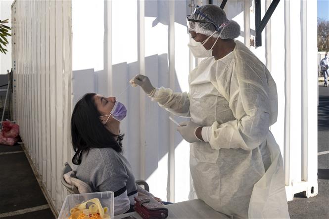 Nhân viên y tế lấy mẫu xét nghiệm COVID-19 cho người dân tại Johannesburg, Nam Phi ngày 28/6/2021. Ảnh: AFP/TTXVN