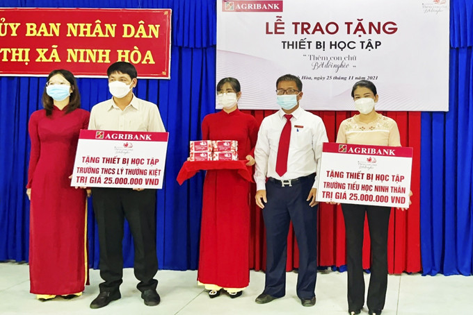 Ông Trần Công Sang - Giám đốc Agribank Chi nhánh thị xã Ninh Hòa  trao tượng trưng cho lãnh đạo Trường THCS Lý Thường Kiệt  và Trường Tiểu học Ninh Thân. 