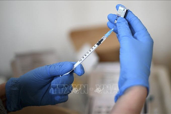 Nhân viên y tế chuẩn bị tiêm vaccine phòng COVID-19 cho người dân tại London, Anh. Ảnh: AFP/TTXVN
