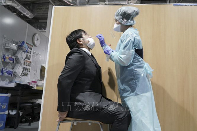 Nhân viên y tế lấy mẫu xét nghiệm COVID-19 cho hành khách tại sân bay Narita, Nhật Bản ngày 2/11/2020. Ảnh: AFP/TTXVN