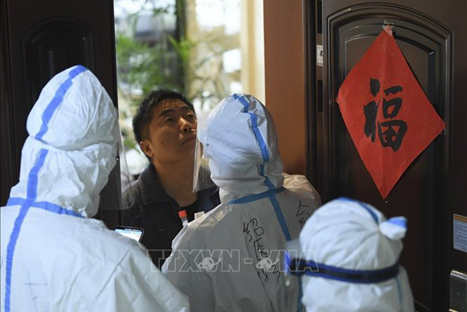 Nhân viên y tế lấy mẫu xét nghiệm COVID-19 cho người dân tại tỉnh Chiết Giang, Trung Quốc, ngày 14/12. Ảnh: THX/TTXVN