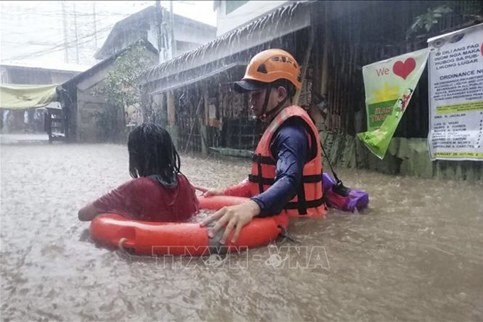 Lực lượng cứu hộ sơ tán người dân khỏi khu vực ngập lụt gây ra bởi mưa lớn do bão Rai tại Cagayan de Oro, phía nam đảo Mindanao, Philippines, ngày 16/12/2021. Ảnh: AFP/TTXVN