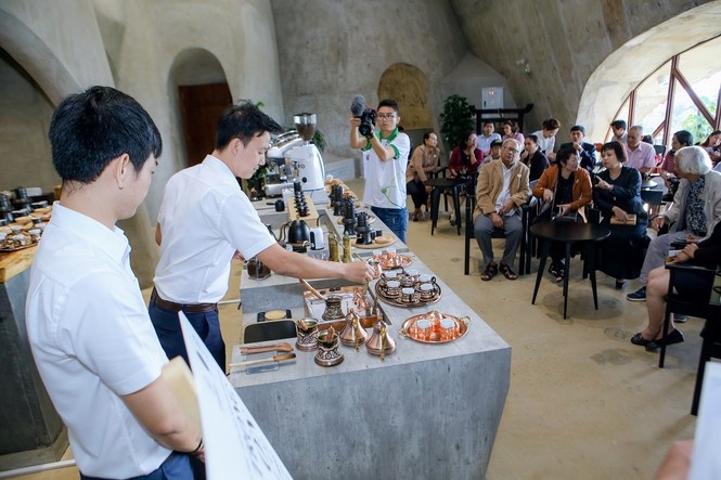 Du khách xem trình diễn pha chế cà phê tại Bảo tàng thế giới cà phê ở TP. Buôn Ma Thuột, Đắk Lắk (ảnh chụp trước dịch Covid-19)