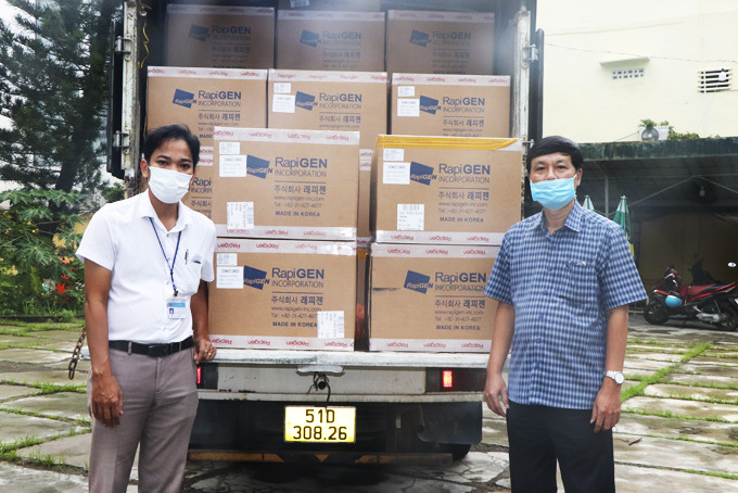Đại diện Ngân hàng Bưu điện Liên Việt chi nhánh Khánh Hòa (bên phải)  trao 100.000 bộ kit test nhanh Covid-19 cho Sở Y tế.