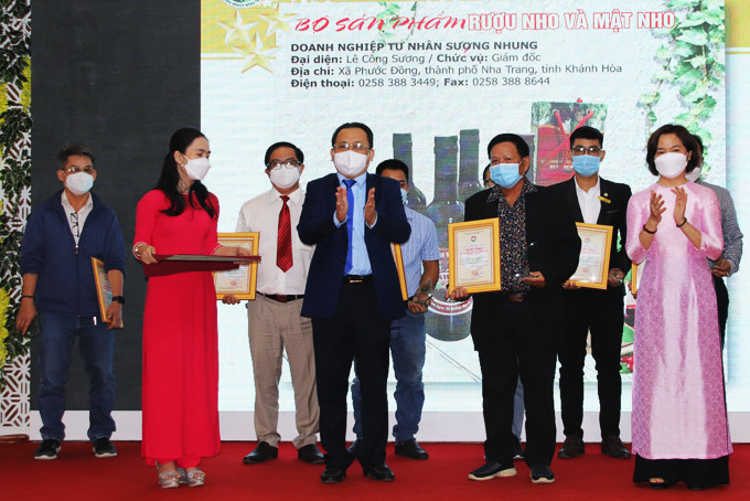Le Huu Hoang and leader of the provincial Department of Industry and Trade offering certificates for units with typical rural industrial products