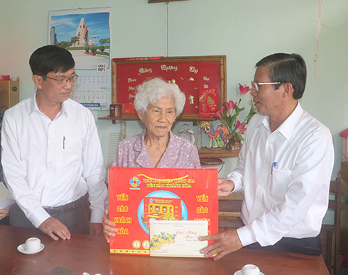 ÔngTrần Ngọc Thanh (bìa phải) tặng quà cho đại diện gia đình ông  Nguyễn Chí Quyết