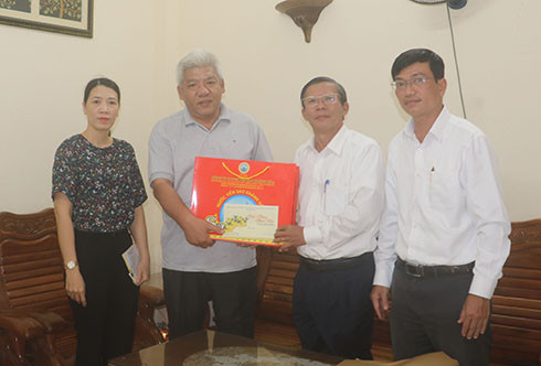 Ông Trần Ngọc Thanh (thứ 2 từ phải qua) tặng quà cho đại diện gia đình ông Nguyễn Văn Chi