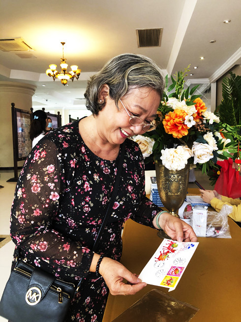 Niềm vui của bà Tô Kim Hoa (TP. Hồ Chí Minh) khi mua được phong bì tem ngày phát hành đầu tiên để kỷ niệm tại Triển lãm tem bưu chính khu vực Nam Trung Bộ 2020 tại Khánh Hòa