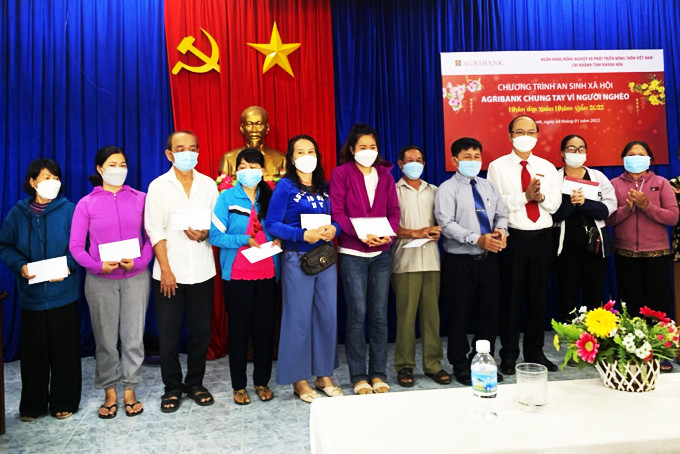 Lãnh đạo Agribank TP. Cam Ranh cùng lãnh đạo UBMTTQ Việt Nam thành phố  trao quà cho người dân.