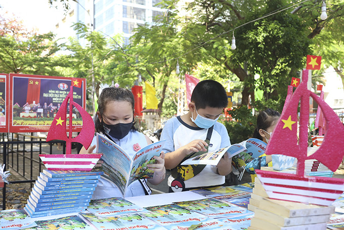 Children reading newspaper publications at Spring Newspaper Festival 2022