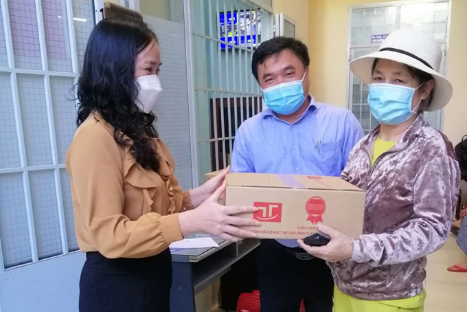 Ông Đinh Viết Thuận, đại diện công ty và bà Đặng Thị Nhã, Phó chủ tịch UBND phường tặng quà cho người dân