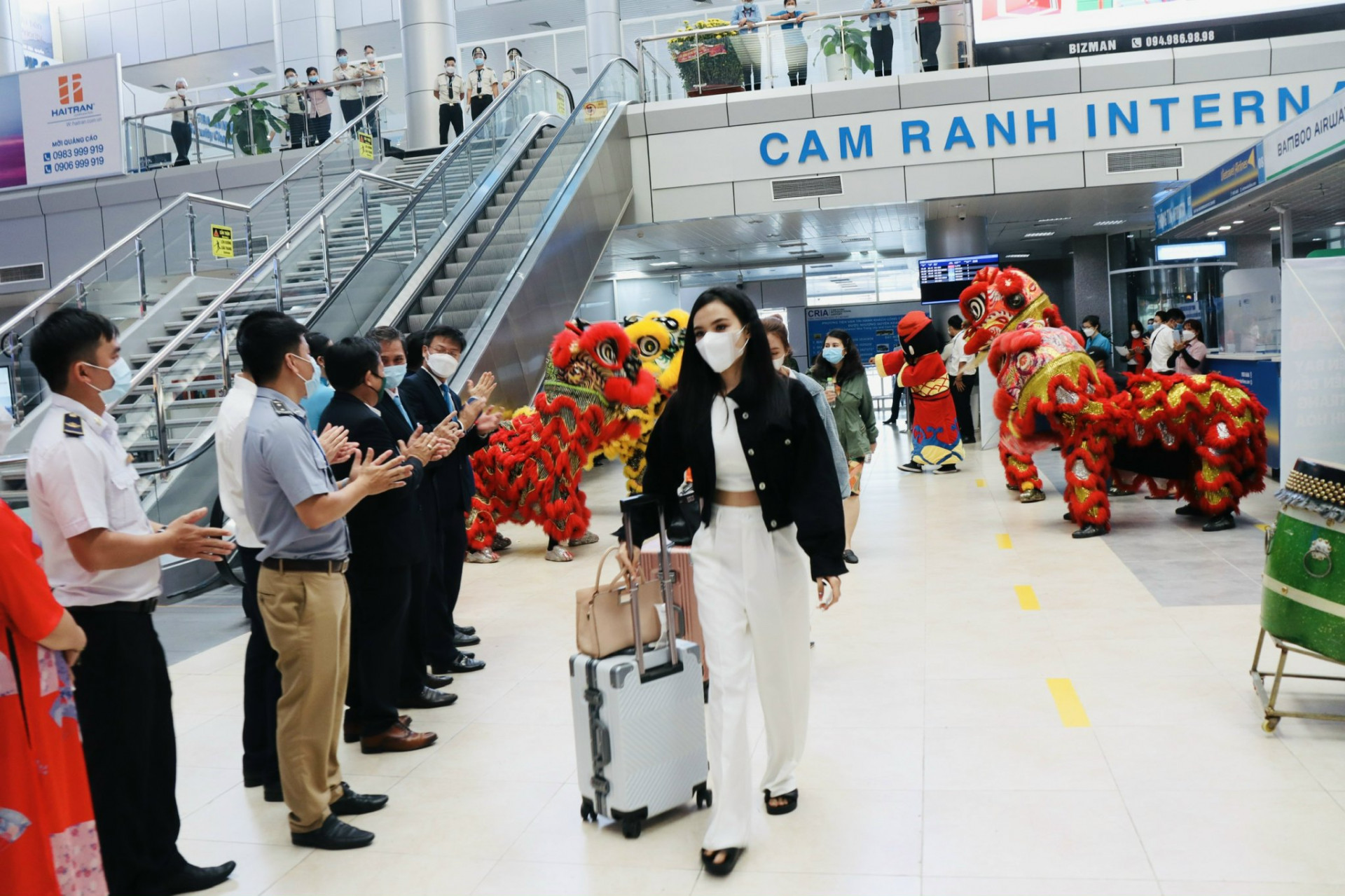 Khách du lịch đi qua Nhà ga nội địa sân bay quốc tế Cam Ranh trong sự chào mừng của đội lân và các đại biểu
