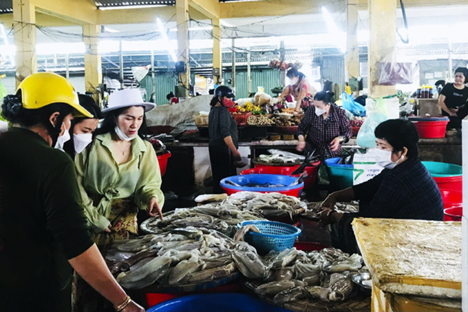 Người dân mua hải sản  tại  chợ Xóm Mới.